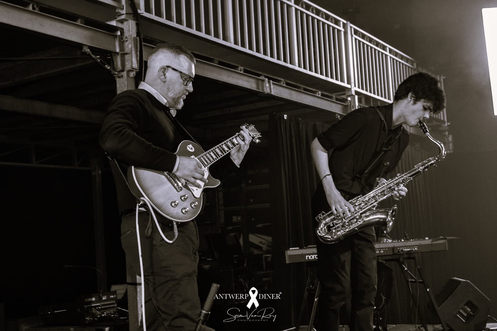 Saxophonist performing on stage alongside a guitarist